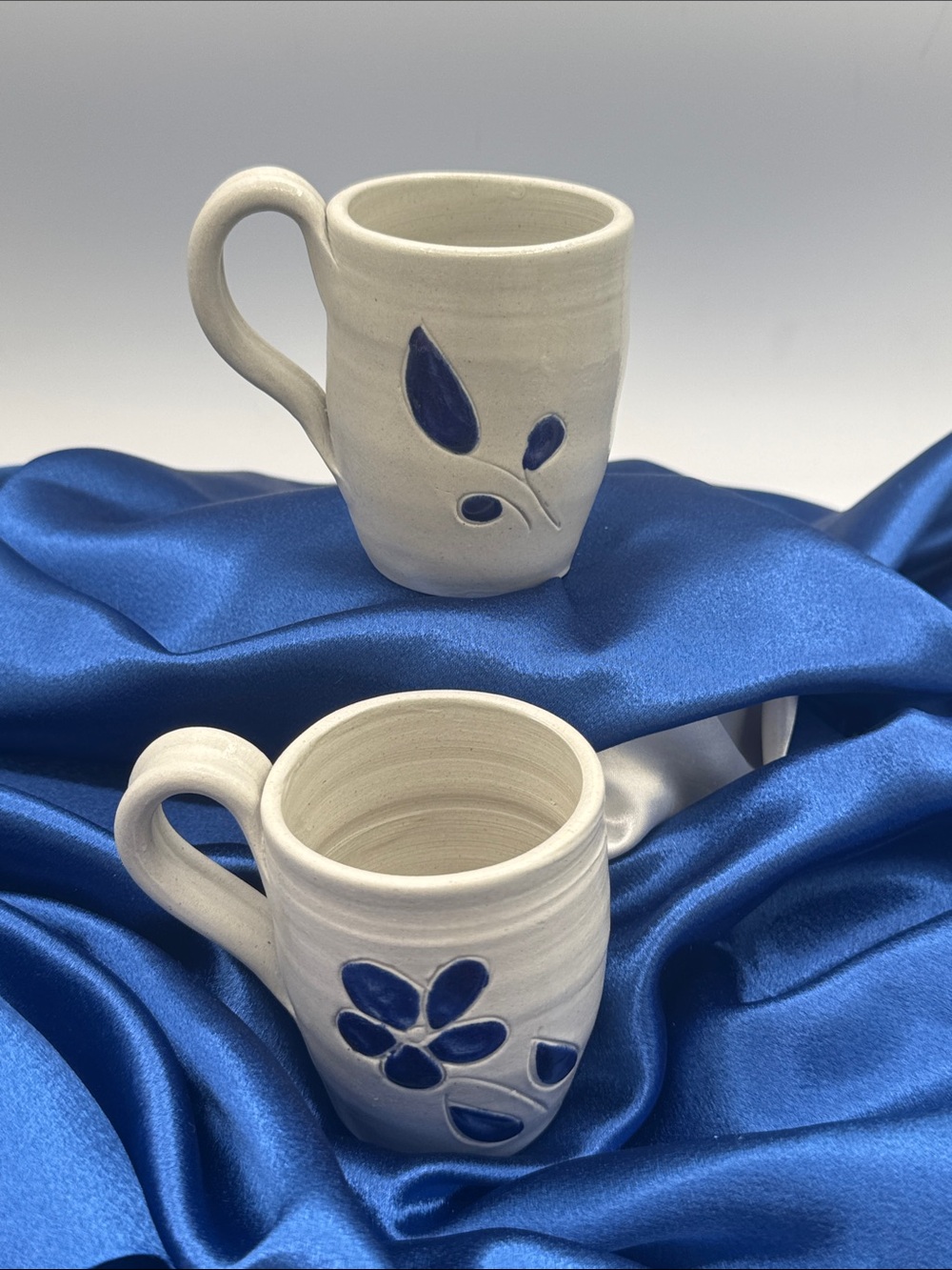 A pair of vintage Williamsburg Pottery salt-glazed stoneware mugs.